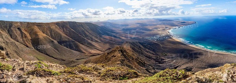 Panorama at Castillejo viewpoint, view from the Risco de Famara cliffs to the coast and the sea with Famara beach, Playa de Famara with La Calaeta, Lanzarote, Canary Islands, Spain