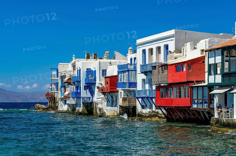 Mykonos, Cyclades, Greece - Little Venice is a picturesque neighborhood in Mykonos Town with colorful houses that stand right by the sea and are reminiscent of Venice. Little Venice is located on Alefkandra Bay next to the famous windmills of Mykonos. Mykonos is part of the Cyclades archipelago in the Aegean Sea