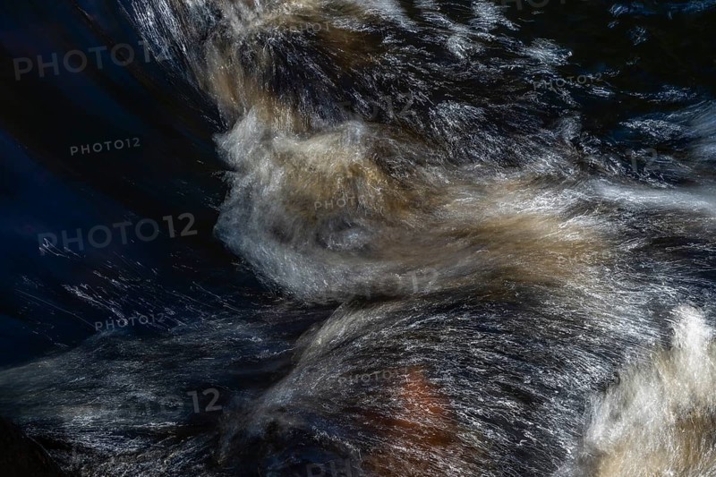 Stream flow with dark water, reflections and turbulences, long exposure, Sweden