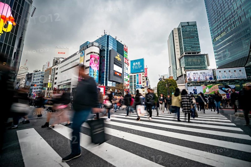 Crowd crossing zebra crossing on a large intersection, motion blur, back modern houses with colorful neon signs, long exposure, Shibuya Crossing, Shibuya, Tokyo, Japan