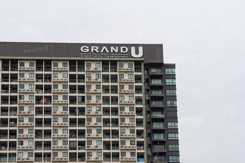 Exterior façade of a residential high-rise building of Condo U (a brand or series name of the Thai real estate developer Grand Unity Development Co., Ltd. (often abbreviated Grand U), Bangkok Yai district, the old town of Bangkok, Thailand