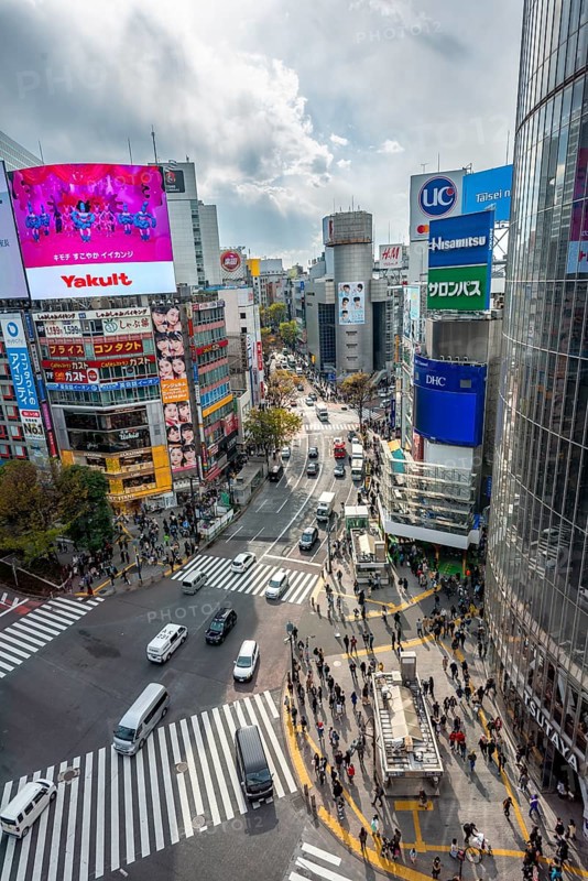 Modern houses with colorful neon signs and large road intersection, Shibuya Crossing from above, crowd at crossroads with crosswalks, Shibuya, Tokyo, Japan