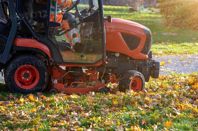 Removing leaves with a riding mower in a public park, Mutterstadt, Rheinland Pfalz