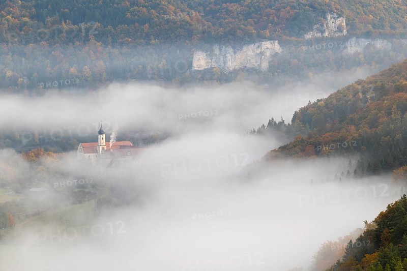 View of Benedictine monastery Beuron, Archabbey of St. Martin, limestone rock, rock face, mixed forest, autumn colours, fog, autumn, Fridingen, Danube Valley, Upper Danube nature park Park, Baden-Württemberg, Germany
