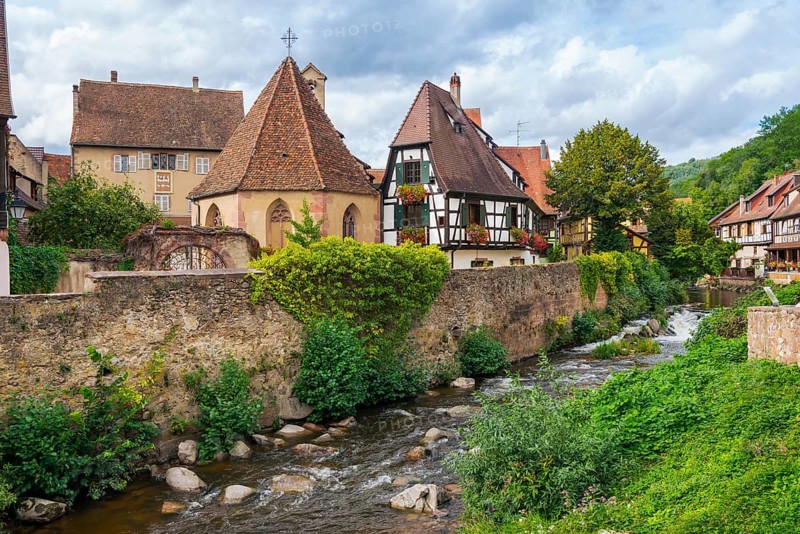 Picturesque Kaysersberg with half-timbered houses on the Weiss river in the old town centre