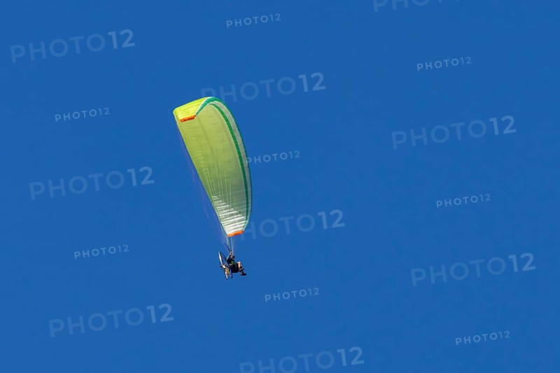 Paraglider flying in a blue sky, England, United Kingdom