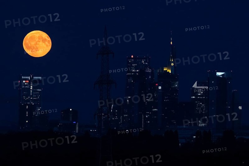 The full moon passes over the Frankfurt banking skyline, Frankfurt am Main, Hesse, Germany