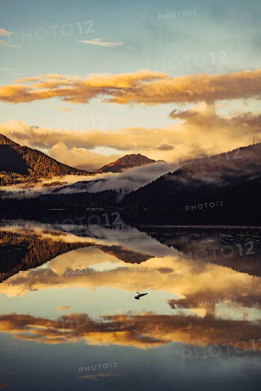 Sunrise with reflections and alpenglow in Lake Heiterwanger See in Tyrol in the Alps in Austria