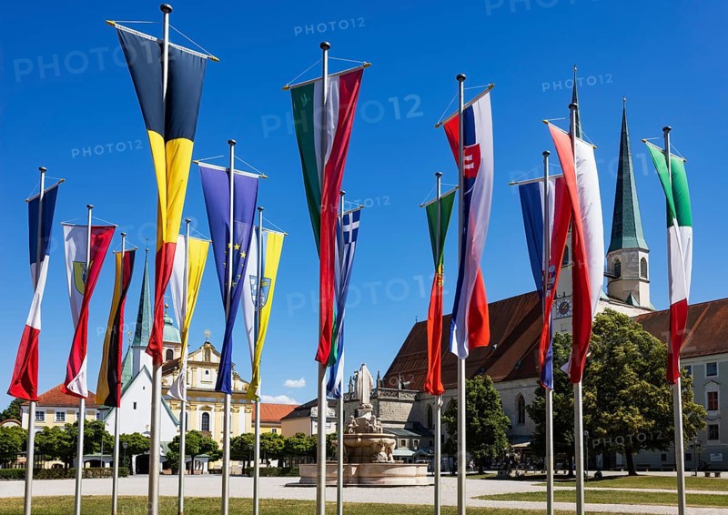 National flags at Kapellplatz with the collegiate parish church of St Philip and St James, place of pilgrimage, Altötting, Upper Bavaria, Bavaria, Germany