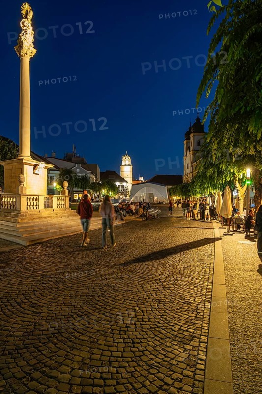 Night shot of the plague column column commemorating the victims of the plague at the beginning of the 18th century, in the background is Trencín Castle, Capital of Culture 2026, Trencín, Slovakia