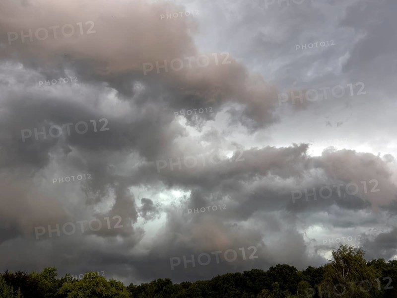Dark discoloured thunderclouds Cloud roll moves over forest area above grey clouds Rain clouds herald thunderstorms, Germany