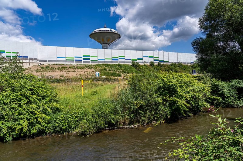 The river Dhünn, 40 km long river, which flows into the Wupper near Leverkusen, renaturalised section, here shortly in front of the mouth along the A1 motorway, at the Leverkusen-West junction, noise barrier, landmark water tower Leverkusen, North Rhine-Westphalia, Germany