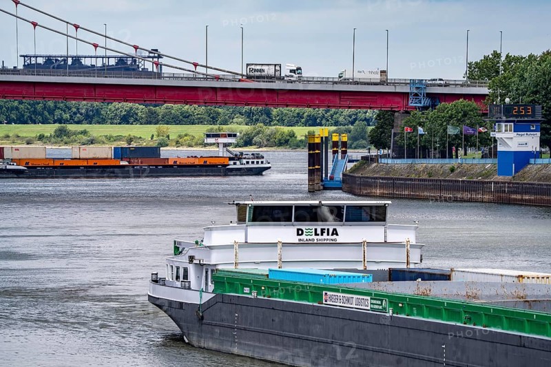 Barge enters the Vinckekanal, in the harbour of Ruhrort, container freighter on the Rhine, on an uphill journey, Friedrich-Ebert-Bridge, road bridge over the Rhine between Homberg and Ruhrort, Thyssenkrupp Steel steelworks, Duisburg, North Rhine-Westphalia, Germany