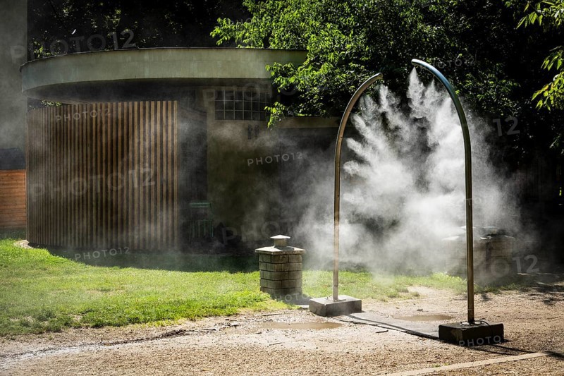 A mobile spray arch sprays fine water mist in a park in Bratislava, Slovakia