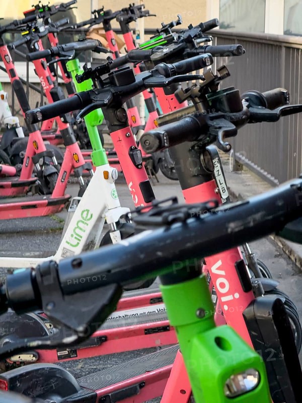 Many rental e-scooters parked on a pavement in Wuppertal, Germany