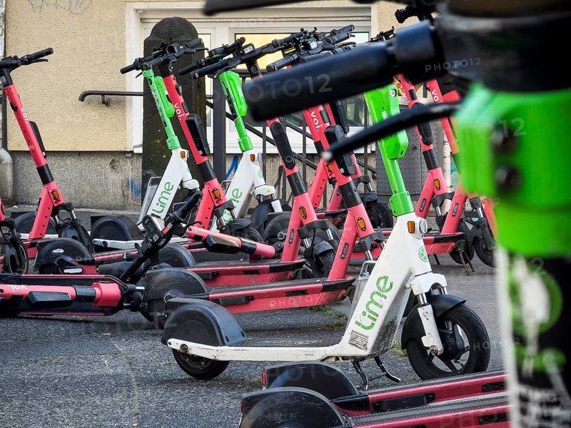 Many rental e-scooters parked on a pavement in Wuppertal, Germany