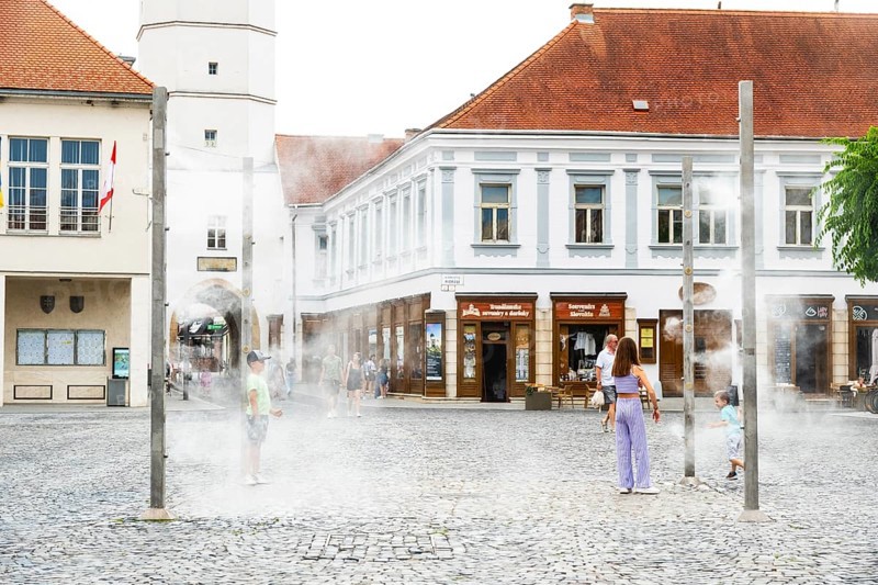 Water mist system in the city centre of Trencin, children use the refreshment in the summer heat, Trencín, Slovakia