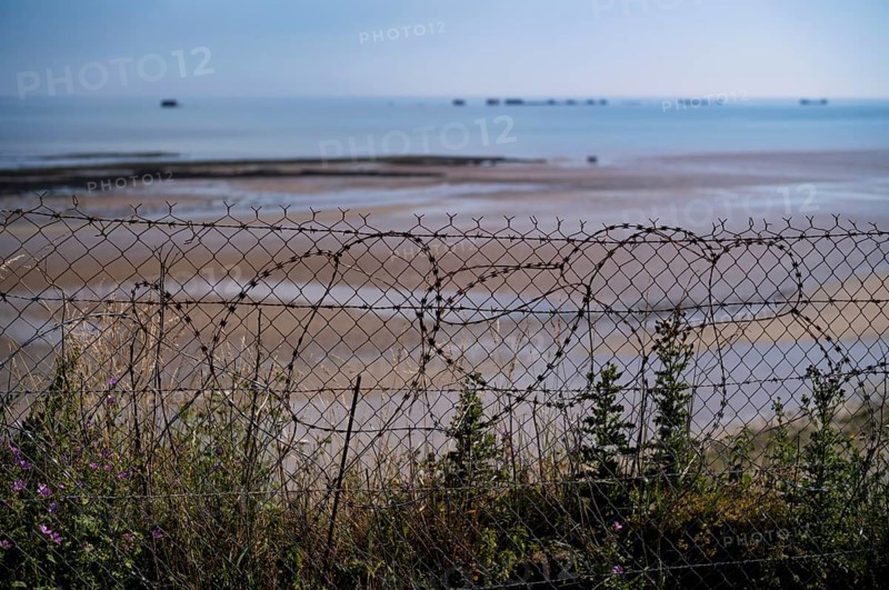 Barbed wire in front of Phoenix Caissons, caissons, concrete boxes, were used in the sea as breakwaters and to form an improvised harbour, Mulberry B Harbour, Mulberry Harbour, Port Winston, Gold Beach, beach, D-Day, Operation Overlord, Arromanches-les-Bains, Normandy, Calvados, France
