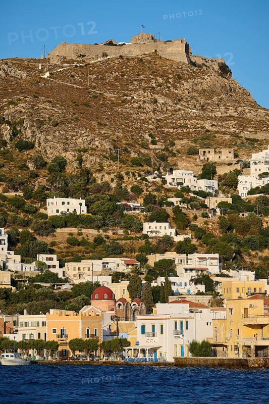 Panteli Fortress, White houses stretch along a hill with a fortress at the top and the sea in the foreground, Agia Marina, Leros, Dodecanese, Greek Islands, Greece