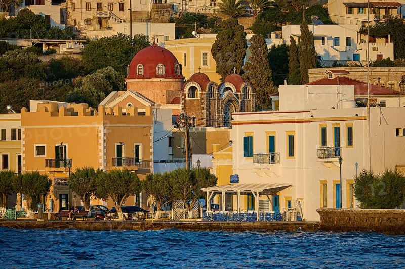 Colourful coastal houses with church and trees by the water, sunny city panorama, Agia Marina, Leros, Dodecanese, Greek Islands, Greece