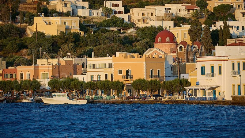 Colourful coastal houses and church by the sea with trees, sunny Greek town view, Agia Marina, Leros, Dodecanese, Greek Islands, Greece