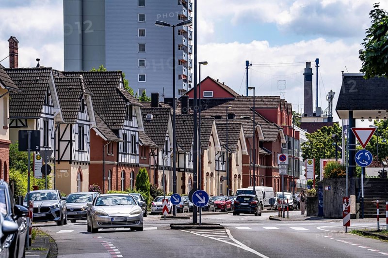 Residential buildings, on Nobelstrasse, in the Wiesdorf district, in Leverkusen, Bayer AG's Plant Estate II, heritage-protected building, in the background residential tower block and Bayer Cross in Chempark Leverkusen, North Rhine-Westphalia, Germany