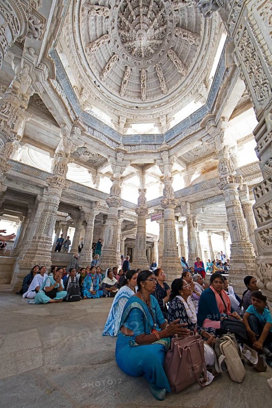Indian woman praying between the white marble pillars in the Adinath temple in Ranakpur, Jain temple, Rajasthan, India