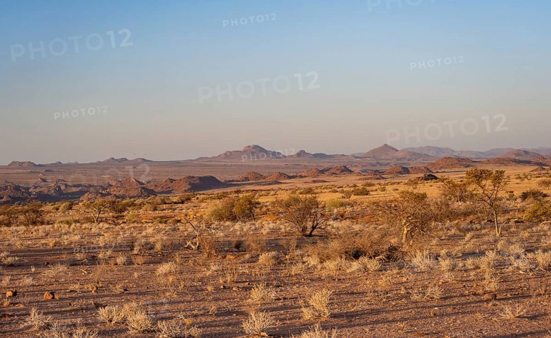 Desert landscape in the evening light at sunset, barren landscape with hills of stacked rocks, Erongo, Damaraland, Namibia