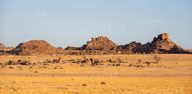 Barren landscape with hills of stacked rocks, desert landscape in the evening light at sunset, Erongo, Damaraland, Namibia