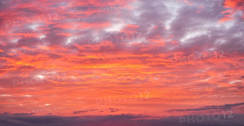 Background image for sky replacement, evening sky with illuminated red clouds at dusk after sunset