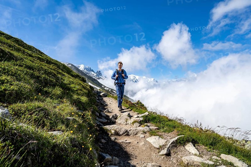 Mountaineer on a hiking trail, inversion weather situation with clouds in the valley, Chamonix, Haute-Savoie, France