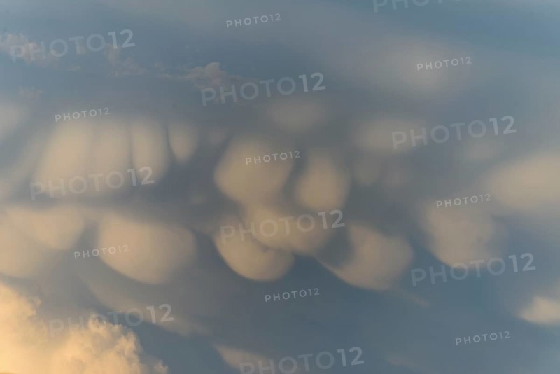 Unusual cloud structures create captivating shapes against a backdrop of warm colours as the sun sets, bringing a serene yet dramatic atmosphere to the evening sky. Bas rhin, Alsace, grand est, France