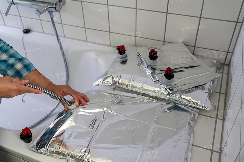 Filling a 10 litre water bag, for storing drinking water at home, as an emergency reserve in the event of a blackout or similar, lightweight, foldable, reusable bag made of multi-layer film, with dispensing device, for long-term storage of up to one year, recommended 3 litres of drinking water per person, for 10 days of storage