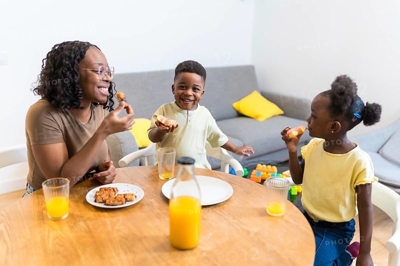 Mother and children enjoying a healthy breakfast together at the dining table, creating a warm and loving family moment