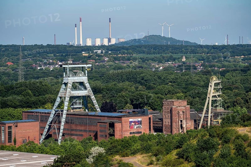 The double headframe of the disused Ewald mine, shaft 7, on the right headframe shaft 2, in Herten, in the background the UNIPER coal-fired power station Scholven, Gelsenkirchen, Scholten spoil tip with 2 wind turbines, North Rhine-Westphalia, Germany