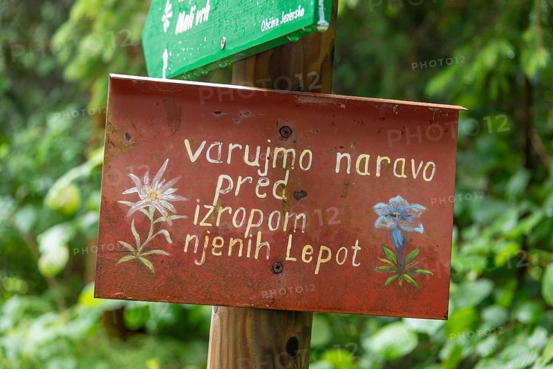Sign with Slovenian text in front of a green, natural backdrop, Zgornje Jezersko, Gorenjska, Slovenia