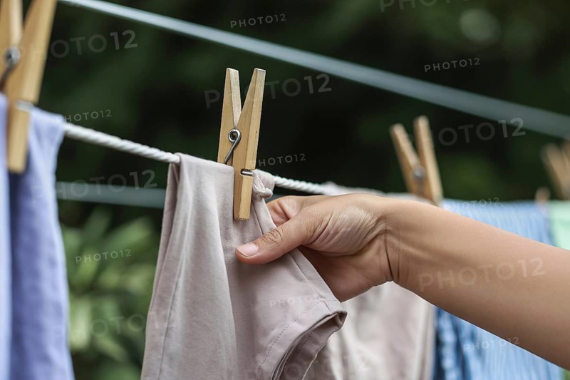 Close up of laundry hanging with wooden cloth pegs. Everyday household routine and simplicity. Generative ai, AI generated