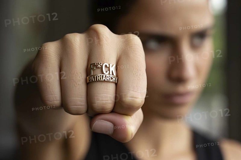 Close-up of female fist wearing bold ring with text F*ck patrarchy. Symbol of feminist resistance and rejection of patriarchy. Generative ai, AI generated