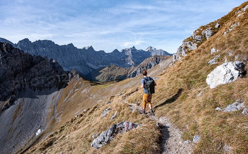 Mountaineers on a hiking trail at the Gamsjoch, picturesque mountain landscape in autumn, view of the rocky mountain ridge of the Hinterautal-Vomper chain, Rißtal in the Eng, Karwendel, Tyrol, Austria