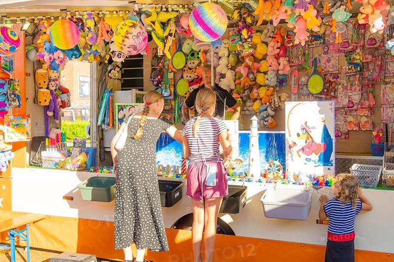 Children and adults play at a colourful stand at a fair, 950 years Weil der Stadt ceremony, Böblingen district, Germany