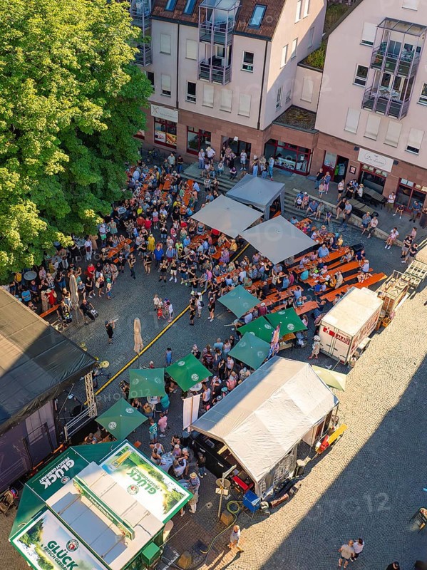Aerial view of a town festival with numerous people and tents on a town square in sunny weather, 950 years Weil der Stadt ceremony, Böblingen district, Germany