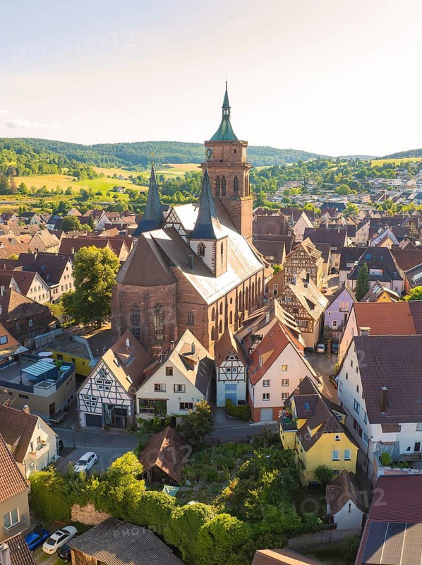 Large church building surrounded by traditional half-timbered houses in a rural setting, 950th anniversary of Weil der Stadt ceremony, Böblingen district, Germany