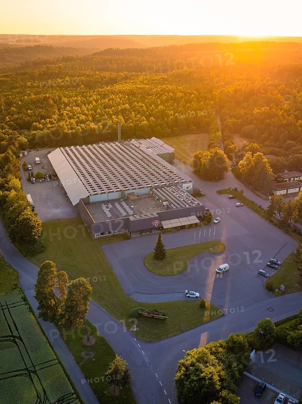 Factory building from the air at sunset, surrounded by woods and roads, Schnaufer sparkling wine cellars, Althengstett Calw