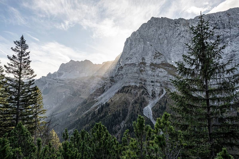 Sunbeams fall over a rocky mountain ridge, Mountain landscape in autumn in the morning light, Rocky mountain peak of the Spritzkarspitze, Rißtal in the Eng, Karwendel, Tyrol, Austria