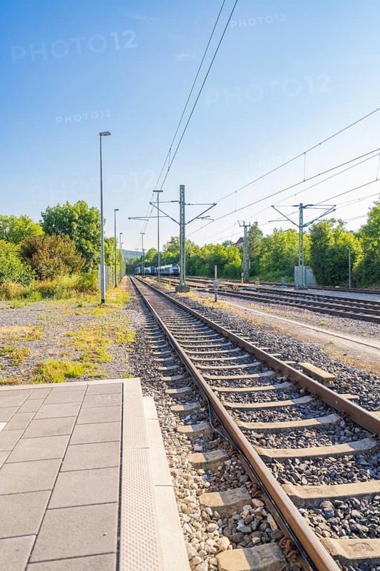 View along the railway tracks in a green environment, clear sky, feeling of travelling, Weil der Stadt railway station, Böblingen district, Germany