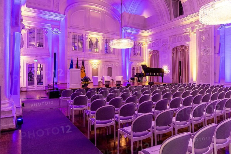 New Palace, White Hall. Interior view of the historic ballroom with festive lighting and rows of chairs. Stuttgart, Baden-Württemberg, Germany