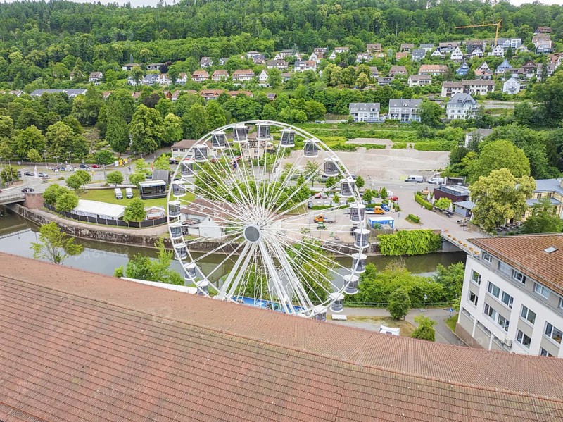 Ferris wheel with a view of a country town, river and green areas in summer weather, Ferris wheel construction, Calw, Black Forest, Germany