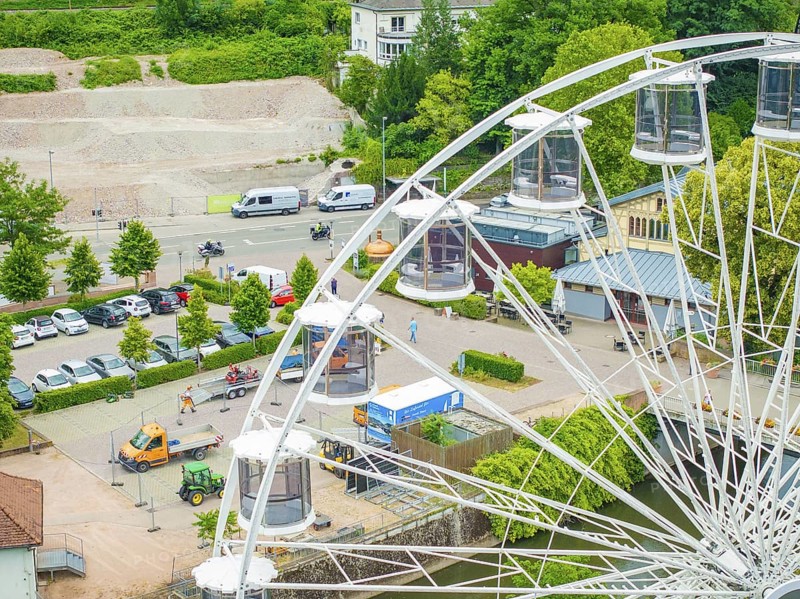 Ferris wheel with visible cabins, parked cars and green surroundings, construction of Ferris wheel, Calw, Black Forest, Germany