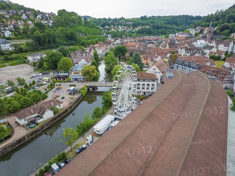 Aerial view of a town with a Ferris wheel in the centre, surrounded by densely built-up houses and a river, construction of a Ferris wheel, Calw, Black Forest, Germany