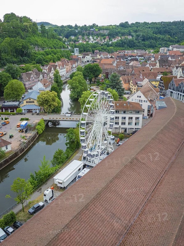 View of a Ferris wheel in an urban area with a river and hilly, green surroundings, construction of a Ferris wheel, Calw, Black Forest, Germany